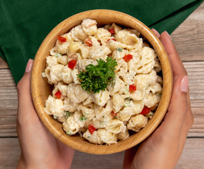 macaroni and cheese in bowl with peppers and parsley