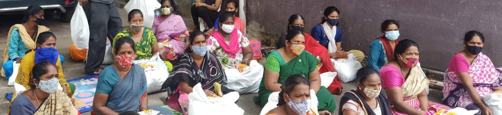 Indian women seated and wearing COVID masks